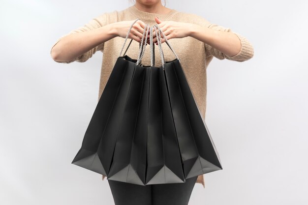 Foto la muchacha sostiene bolsas de papel negras. bolsa de papel.