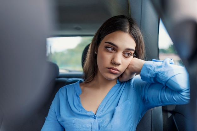 Muchacha triste de la mujer o del adolescente que mira a través de una ventanilla del coche