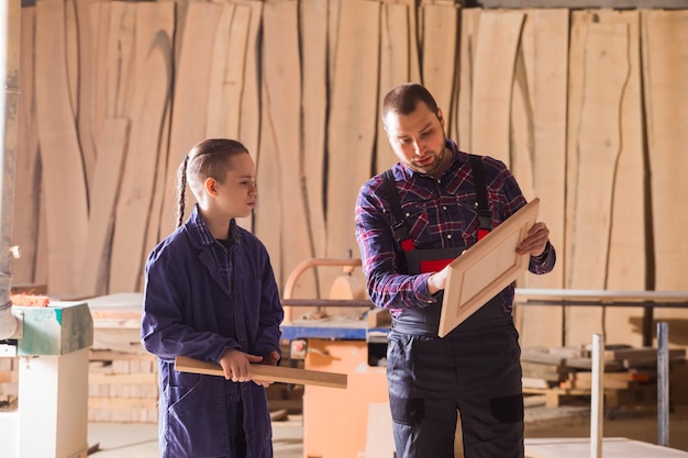 Muchacho adolescente alegre en el trabajo de sus sueños en el taller de carpintería