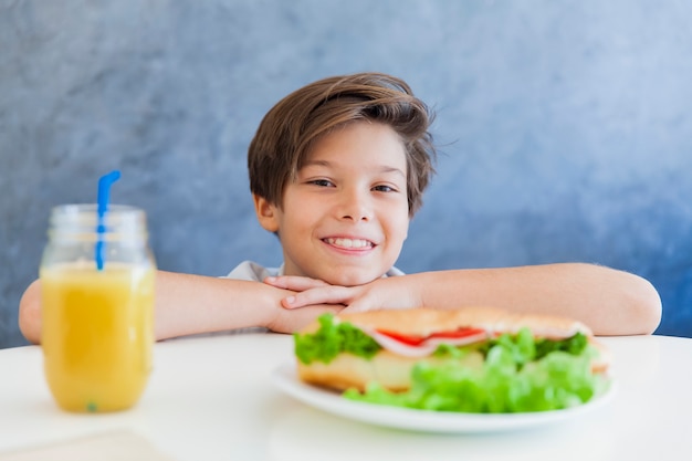 Muchacho adolescente feliz desayunando en casa