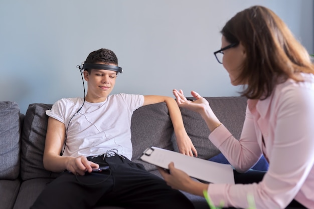 Muchacho adolescente hablando con un psicólogo profesional en la oficina, sesión de terapia individual para adolescentes con el médico. Dificultades de la adolescencia, salud mental, vida social del adolescente