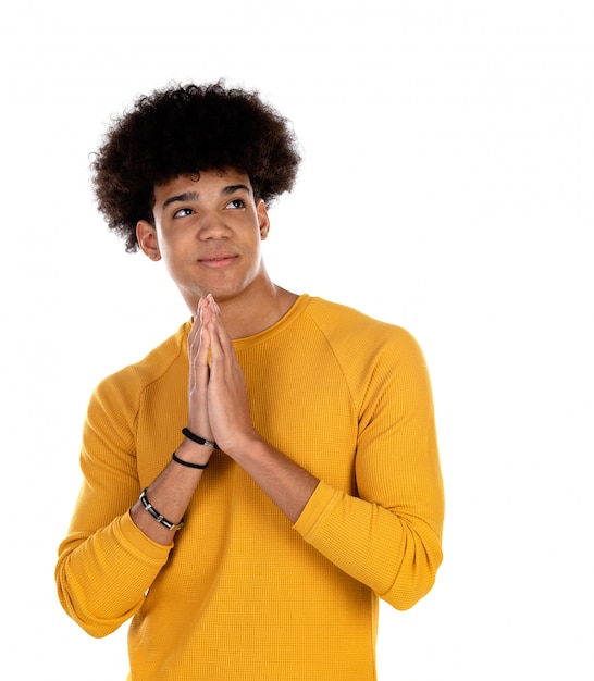 Muchacho adolescente con peinado afro rezando