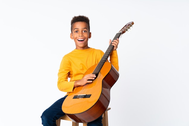 Muchacho afroamericano con guitarra sobre blanco aislado