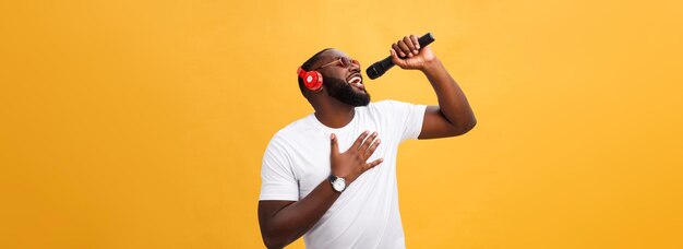 Muchacho afroamericano hermoso joven que canta emocional con micro