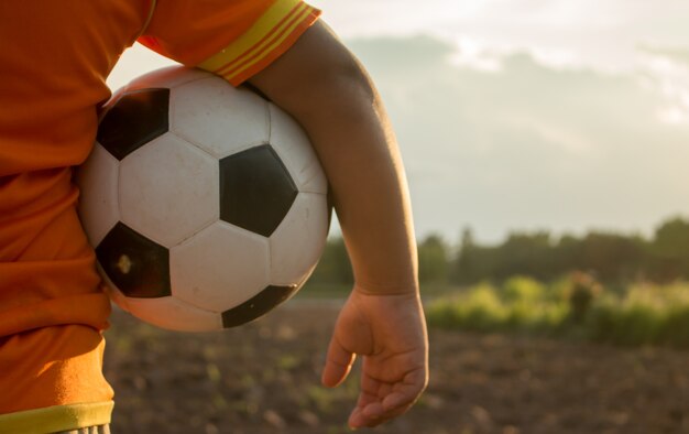 Foto muchacho asiático que sostiene una bola o que juega un juego.