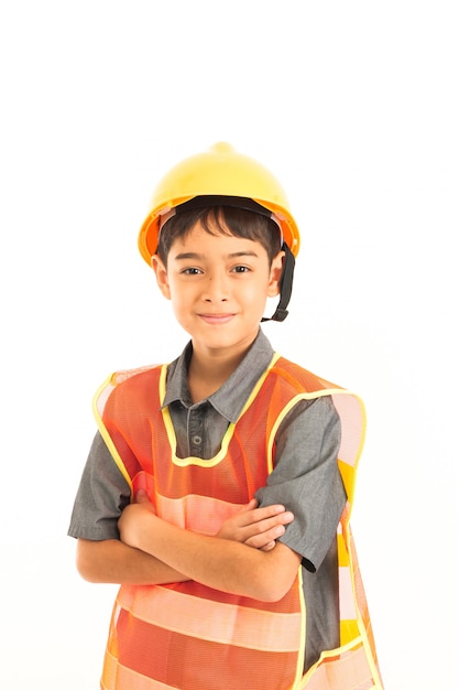 Muchacho asiático con el sombrero amarillo del ingeniero y de la seguridad en el fondo blanco