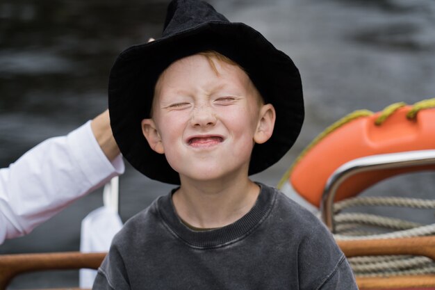 Muchacho atractivo sonriente del pelirrojo en un yate.