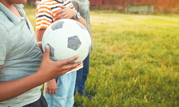 Foto muchacho caucásico con una pelota de fútbol en un campo de fútbol.