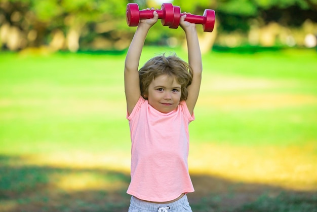 Muchacho deportivo con pesas fitness al aire libre niños salud y energía niños saludables estilo de vida kid exercisi