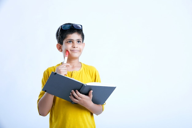 Muchacho lindo indio joven con el cuaderno