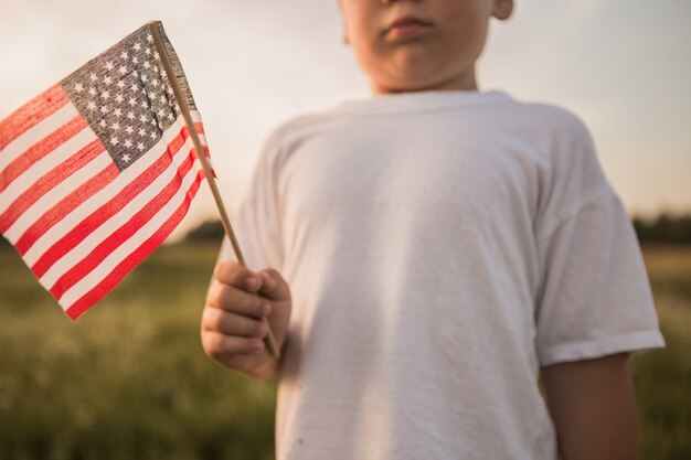 Muchacho sosteniendo una bandera americana en su mano