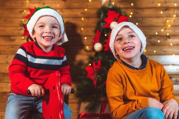 Foto muchachos alegres en casa de madera en navidad