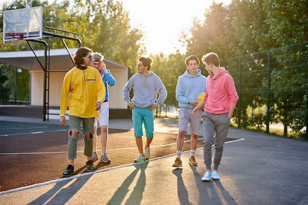 Los muchachos deportivos que van a jugar baloncesto en la calle