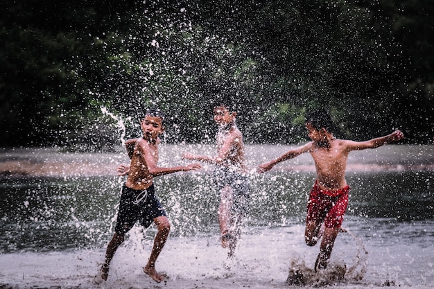 Los muchachos juegan persiguiéndose en el agua.