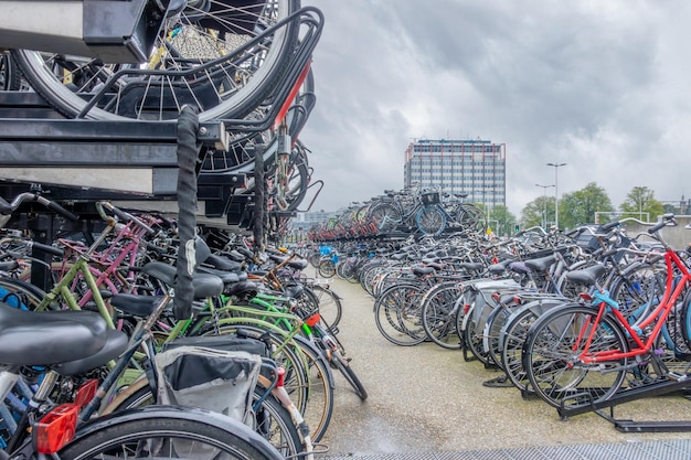 Muchas bicicletas holandesas en un estante de bicicletas de dos pisos cerca de la estación central de Ámsterdam en un día nublado