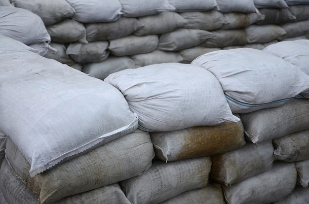 Muchas bolsas de arena sucia para la defensa de las inundaciones. Barrera protectora de sacos de arena para uso militar. Bunker táctico guapo