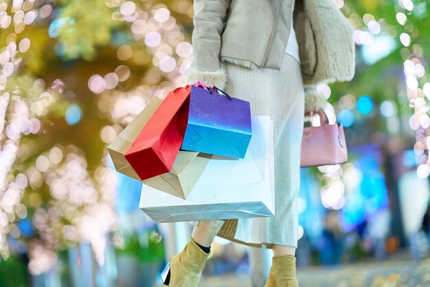 Muchas bolsas de compras sostenidas por una mujer en la ciudad