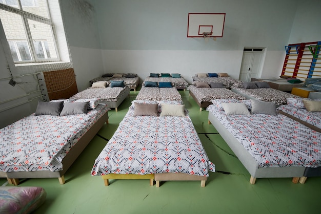 Muchas camas multicolores con almohadas y sábanas en el interior del gimnasio.
