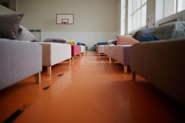 Muchas camas multicolores con almohadas y sábanas en el interior del gimnasio.