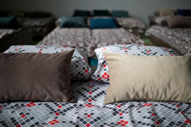 Muchas camas multicolores con almohadas y sábanas en el interior del gimnasio.