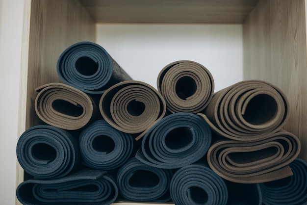 Muchas colchonetas de fitness y yoga de colores retorcidas en rollos vista final sobre fondo blanco aislado