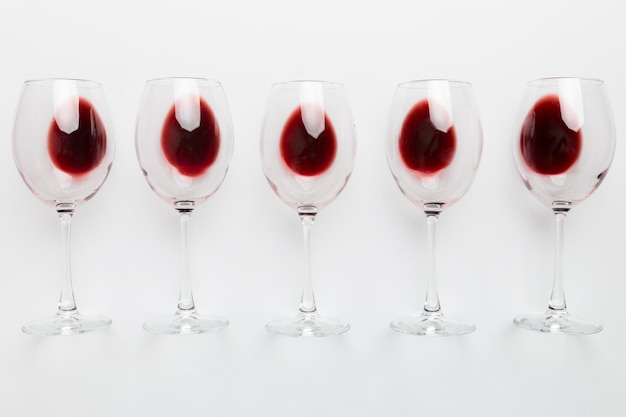Muchas copas de vino tinto en la degustación de vino Concepto de vino tinte en fondo coloreado Diseño de colocación plana de vista superior