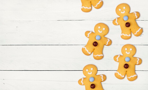 Muchas galletas de Navidad de jengibre en una mesa de madera blanca