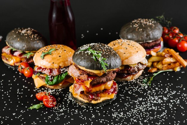 Muchas hamburguesas diferentes con ingredientes sobre un fondo negro