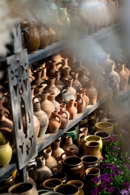 Muchas jarras de arcilla coloridas hechas a mano y jarrones únicos de varias formas en estantes en el mercado local