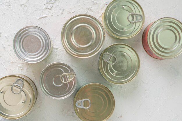 Muchas latas sin abrir con comidas como carne y pescado en la mesa, alimentos conservados