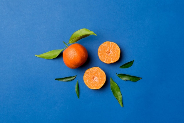 Muchas mandarinas maduras frescas con hojas verdes en el espacio de vista superior de fondo coloreado para texto