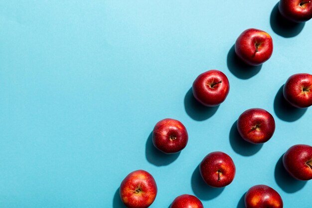 Muchas manzanas rojas sobre fondo de color, vista superior. Patrón de otoño con manzana fresca por encima de la vista.