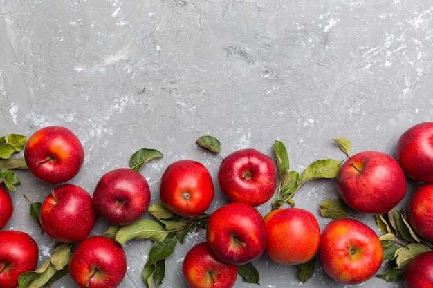 Muchas manzanas rojas sobre fondo de color, vista superior. Patrón de otoño con manzana fresca vista anterior con espacio de copia para diseño o texto