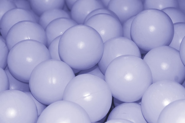Muchas pequeñas bolas de plástico en la piscina Tonificada en el color del año 2022, muy peri