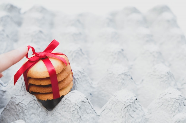 Muchas piezas de galletas unen un lazo rojo en la tela.