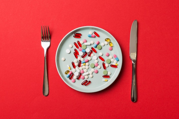 Foto muchas píldoras y suplementos para bajar de peso diferentes como alimento en un plato redondo píldoras que se sirven como una comida saludable drogas medicina de farmacia o concepto médico de cuidado de la salud