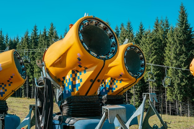 Muchas pistolas de nieve amarillas en el bosque de la fuente Generación de nieve Dispositivo Equipo Tecnología de explosión de verano Ingeniería de mecanismos