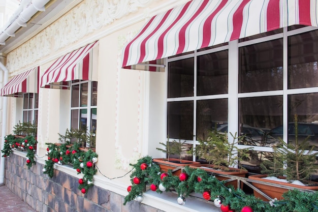 Foto muchas relucientes decoraciones de bolas de árboles de navidad en las ventanas de un café restaurante