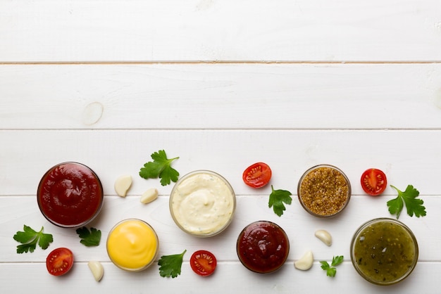 Muchas salsas y hierbas diferentes en la mesa plana vista superior salsas con especias concepto saludable