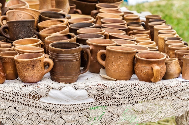 Muchas tazas de arcilla diferentes sobre la mesa a la venta