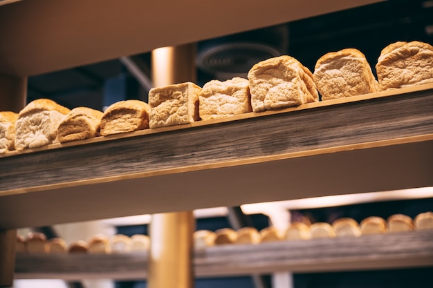Mucho pan cocido fresco del pan en la exhibición de madera.