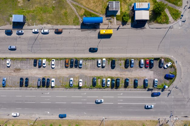 Muchos automóviles están estacionados en un estacionamiento intermitente espontáneo entre dos avenidas en las afueras de la ciudad.