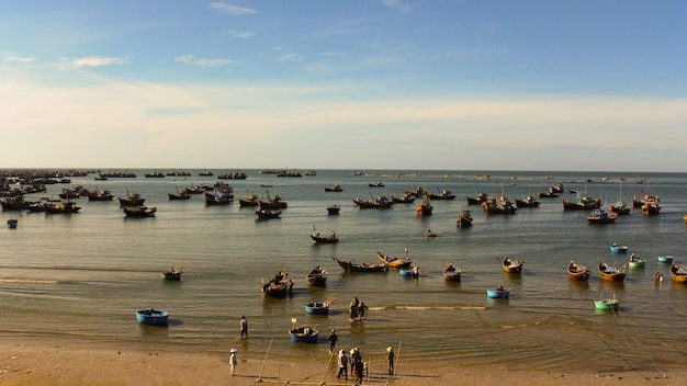 Muchos barcos de pesca flotan en la bahía, pueblo de pescadores en Vietnam