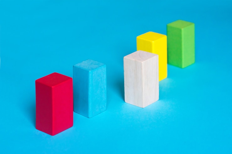 Foto muchos bloques de colores en una fila y un bloque de madera sobre fondo azul