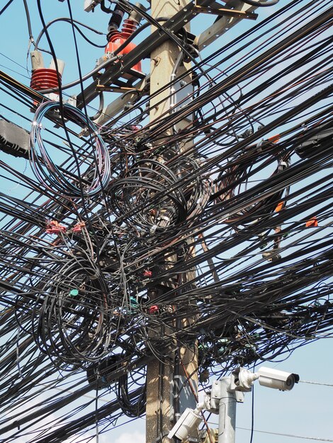 Foto muchos cables eléctricos, cables, líneas telefónicas y cctv en poste de electricidad