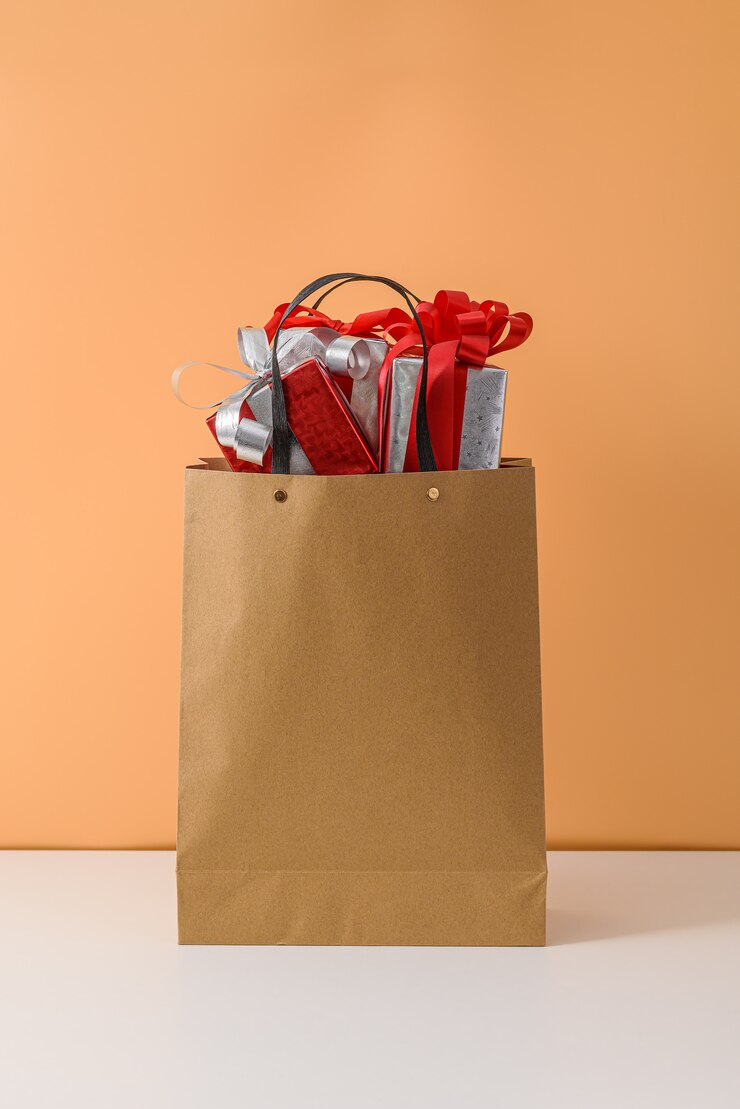Muchos caja de regalo con lazo de cinta roja en bolsa de papel marrón. conceptos regalo de año nuevo o navidad