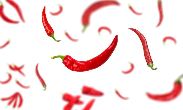 Muchos chiles de especias rojas caen libremente en el fondo.