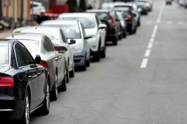 Foto muchos coches aparcados a lo largo de la carretera. falta de, falta de aparcamiento en grandes ciudades.