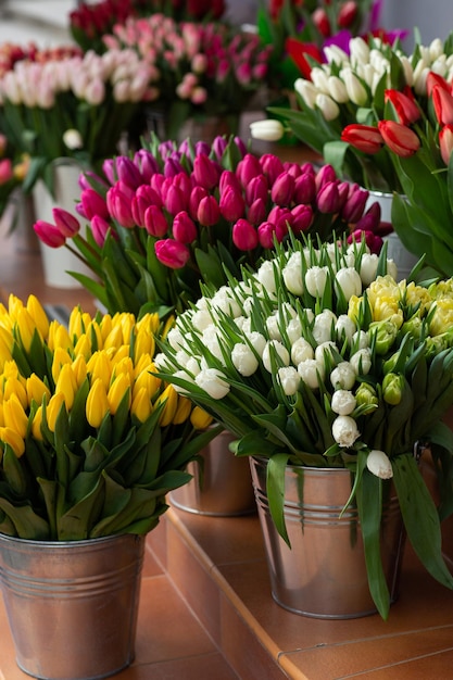 Muchos colores diferentes en la mesa de pie en la tienda de flores Vitrina Fondo de mezcla de flores Hermosas flores para catálogo o tienda en línea Tienda floral y concepto de entrega