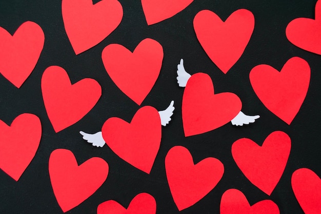 Muchos corazones rojos sobre un fondo negro Tarjeta de felicitación para el día de San Valentín